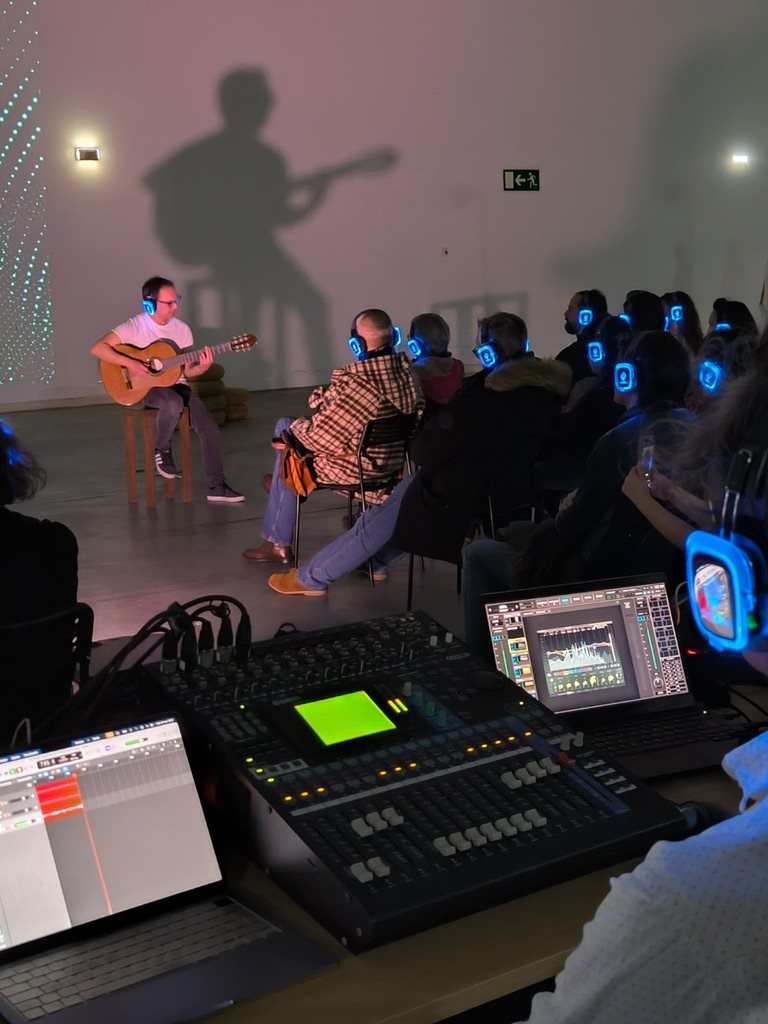 Carlos Pizarro tocando la guitarra clásica con auriculares durante la jornada de trabajo previa en LABoral