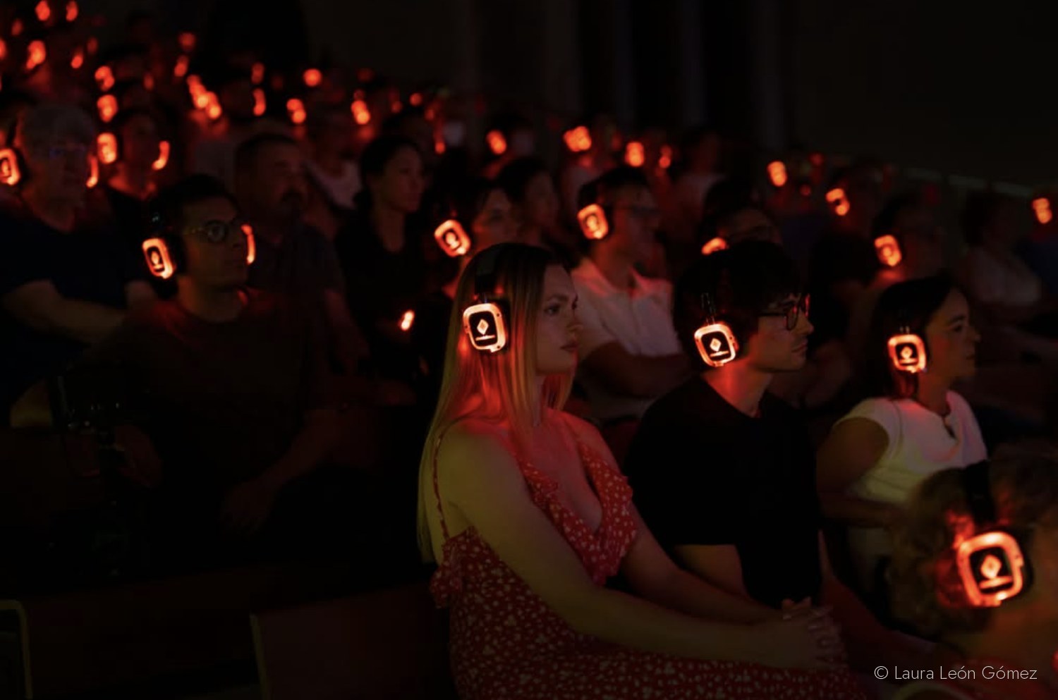 Público en la grada con auriculares inalámbricos iluminados