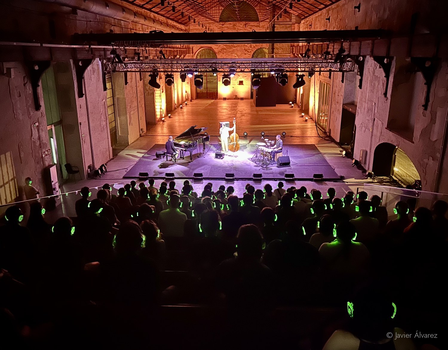 Sala Fundición de la Real Fábrica de Artillería durante un concierto, con el público escuchando con auriculares inalámbricos iluminados